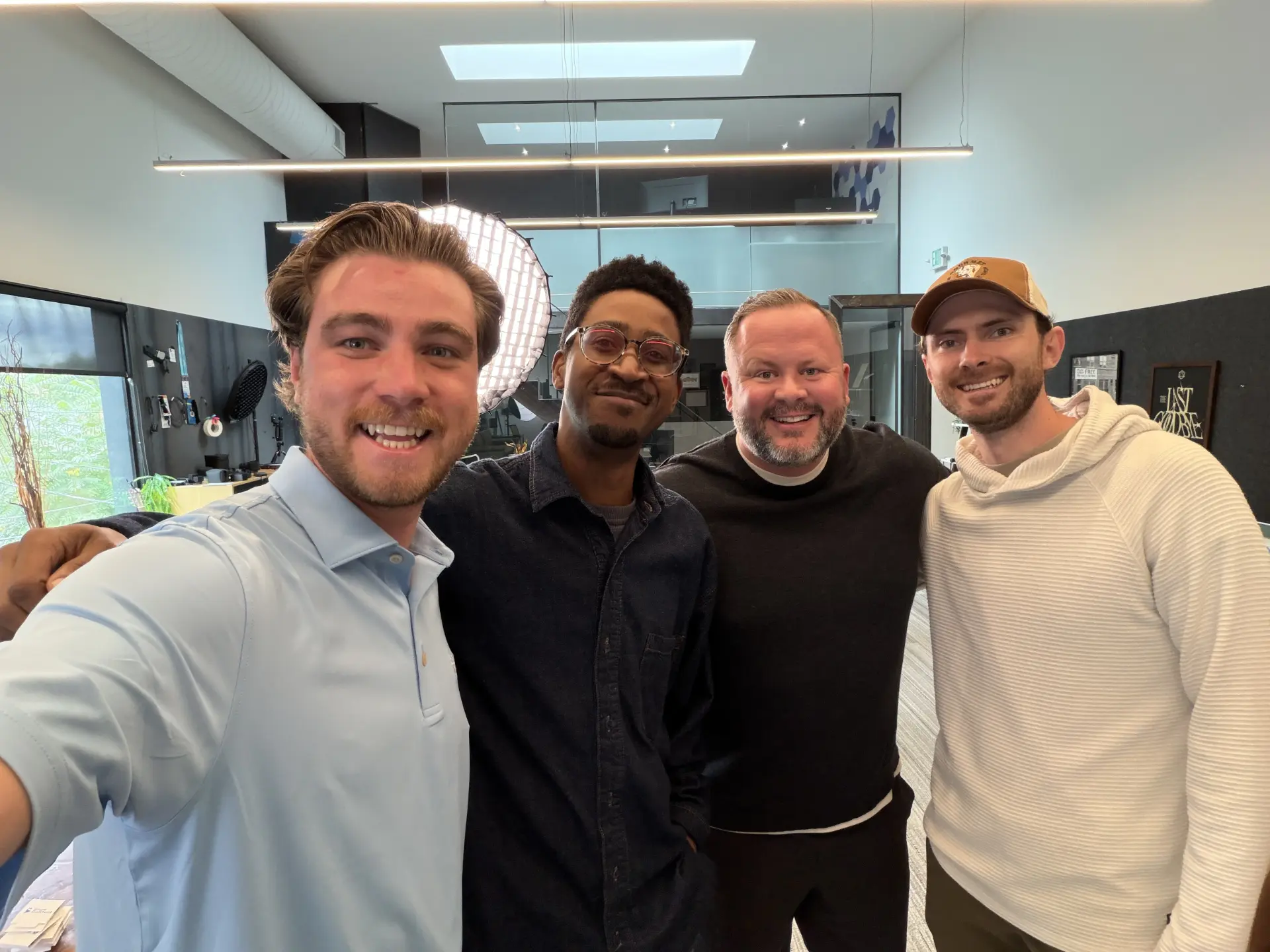 Charley Corbett, MS, CFP®, standing with three members of the SageContent team inside the Denver studio
